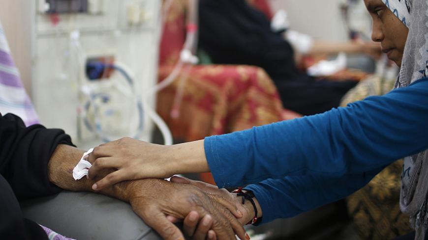 A Palestinian woman tends to her mother undergoing kidney dialysis at al-Shifa hospital in Gaza City September 12, 2013. Cairo closed the Rafah crossing completely on Wednesday after assailants crashed two explosive-laden cars into a security building adjacent to the border zone, killing six Egyptian soldiers. Ashraf al-Qidra, spokesman for the Hamas-run Gaza Health Ministry, said 1,000 patients a month required medical care in Egypt and in other countries. Rafah's closure, he said, would also affect the im
