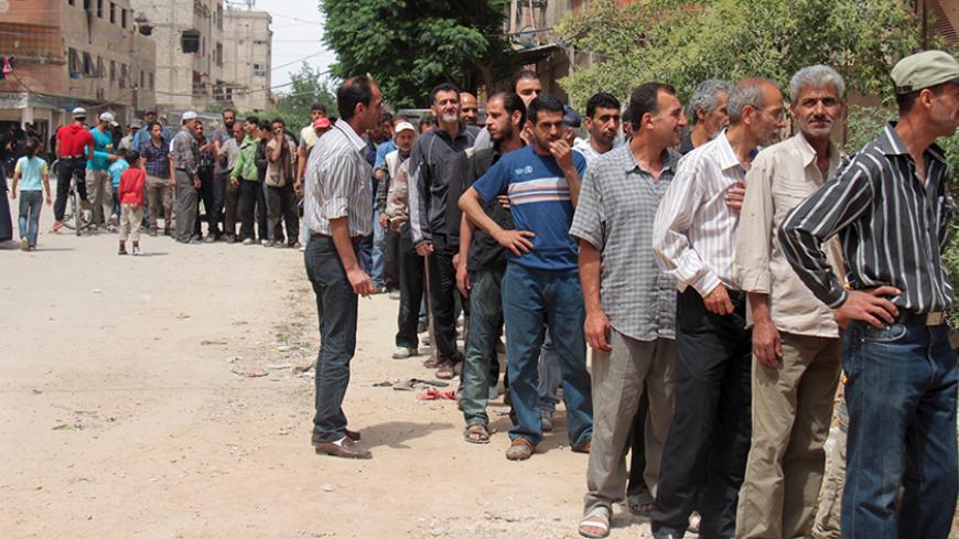 Residents and Palestinians who fled the Yarmouk refugee camp wait in line to receive parcels of humanitarian aid from the United Nations Relief and Works Organization (UNRWA) in the beseiged southern outskirts of Damascus May 23, 2015. REUTERS/Ward Al-Keswani - RTX1E8VS