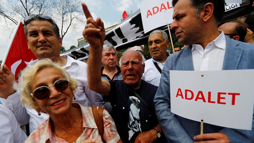 A demonstrator chants slogans during a protest against detention of main opposition Republican People's Party (CHP) lawmaker Enis Berberoglu, in Istanbul, Turkey June 15, 2017. The placard reads "Justice". REUTERS/Murad Sezer - RTS176U2