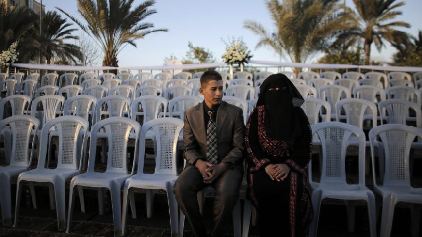 A Palestinian couple waits before a mass wedding ceremony in the West Bank city of Jericho January 28, 2014. A spokesman working together with the Palestinian Presidential Office said some 300 Palestinian couples, 80 of them from the Gaza Strip, wedded on Tuesday in the mass ceremony funded by the Presidential Office and attended by President Mahmoud Abbas. Each couple would also be given $4,000, the spokesman said. REUTERS/Ammar Awad (WEST BANK - Tags: SOCIETY) - RTX17YR6