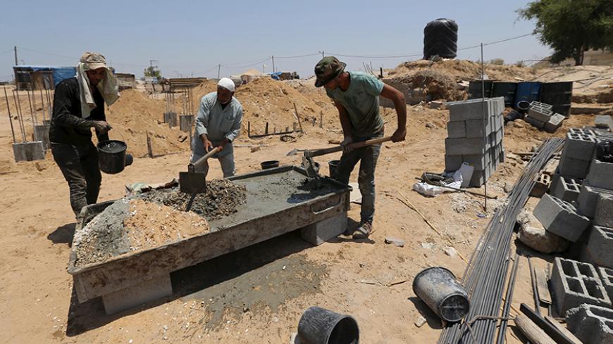 Palestinian labourers work at the construction site of a house, that witnesses said was destroyed by Israeli shelling during a 50-day war last summer, in Johr El-Deek village near the central Gaza Strip July 26, 2015. The house is rebuilt as part of a Qatari-funded project aimed at reconstructing housing units destroyed during the war. Palestinian Minister of Housing and Public Works Mufeed Al-Hassayna said that the reconstruction process in Gaza has started, almost a year since the 2014 war. More than 100