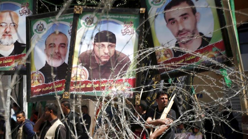 Pictures of Palestinian Hamas militants held in Israeli jails are seen through a fence during a rally marking Palestinian Prisoner Day, in Gaza City April 17, 2016. REUTERS/Mohammed Salem - RTX2AAQR
