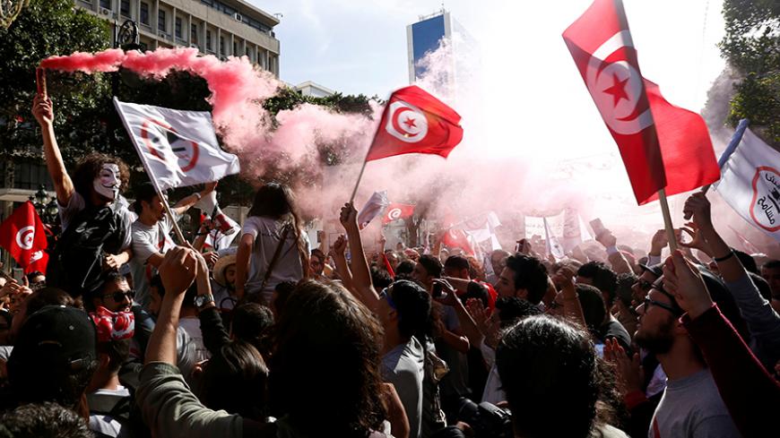 Demonstrators hold flares during a demonstration against a bill that would protect those accused of corruption from prosecution on Habib Bourguiba Avenue in Tunis, Tunisia, May 13, 2017. REUTERS/Zoubeir Souissi - RTX35OSZ