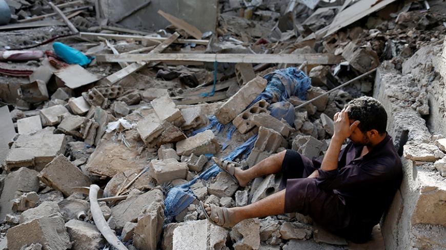 A man sits on the rubble of a house of his relatives, destroyed by a Saudi-led air strike in Sanaa, Yemen June 9, 2017. REUTERS/Khaled Abdullah - RTX39RM6