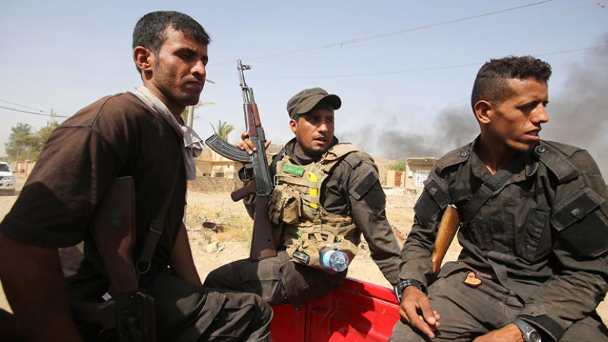 Iraqi Shiite fighters from the Popular Mobilization units ride on the back of a vehicle in the city of Baiji, north of Tikrit, in the Salahaddin province, on June 7, 2015. Iraqi forces advanced against the Islamic State (IS) jihadist group in Baiji as they battled to retake the strategic town for a second time. AFP PHOTO / AHMAD AL-RUBAYE (Photo credit should read AHMAD AL-RUBAYE/AFP/Getty Images)