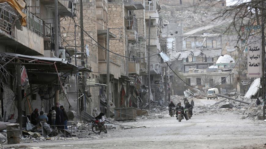 People ride motorcycles amidst the rubble of damaged buildings in the northern Syrian town of al-Bab, Syria, February 28, 2017. REUTERS/Khalil Ashawi - RTS10UG7
