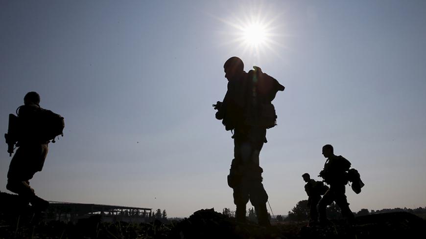 Israeli soldiers are silhouetted as they search for remains of rockets fired from Lebanon on Sunday, near the northern city of Nahariya December 21, 2015. Israel's military said it fired artillery rounds into southern Lebanon on Sunday in response to rockets fired earlier across the border that struck inside Israel. Three rockets fired from Lebanon had struck northern Israel, causing no damage or injuries, hours after a militant leader in the Lebanese group Hezbollah was reported killed in an air strike in 