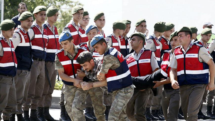 A soldier accused of attempting to assassinate Turkish President Tayyip Erdogan on the night of the failed July 15, 2016 coup is carried by gendarmes to the courthouse in Mugla, Turkey July 14, 2017. REUTERS/Kenan Gurbuz - RTX3BFT0