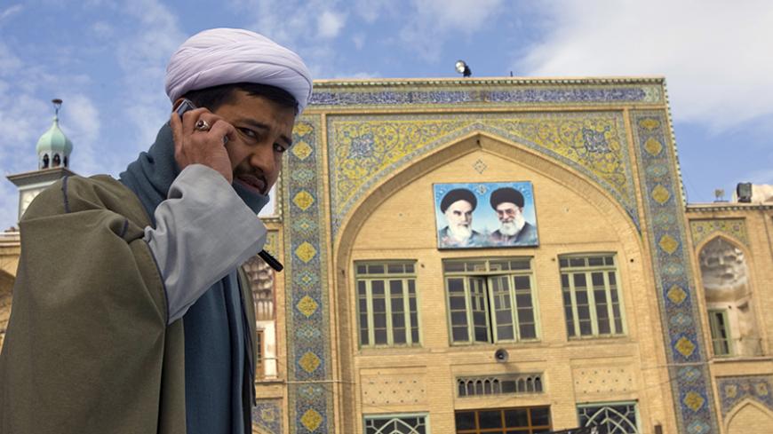 A cleric speaks on his mobile phone on the campus of the Seminary in Qom, 120 km (75 miles) south of Tehran February 3, 2009. REUTERS/Caren Firouz (IRAN) - RTXB72O