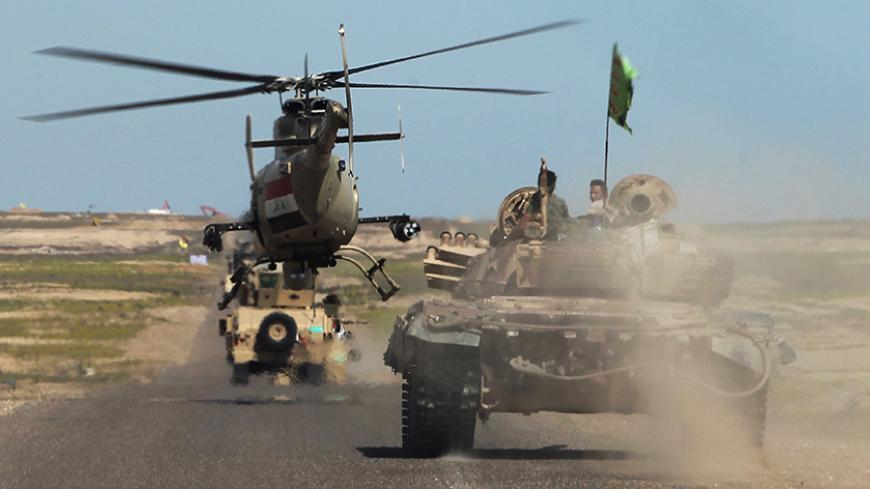 Iraqi army vehicles and a helicopter deploy in the front line in al-Anbar desert, 50 kms north east of Haditha, where the country's forces are fighting the Islamic State (IS) jihadist group, on March 9, 2016.
Counter-terrorism forces, soldiers, police and allied paramilitaries are taking part in an operation launched on March 1, which is backed by artillery and both Iraqi and US-led coalition aircraft, aimed at retaking areas north of Baghdad, according to the Joint Operations Command. / AFP / AHMAD AL-RUBA