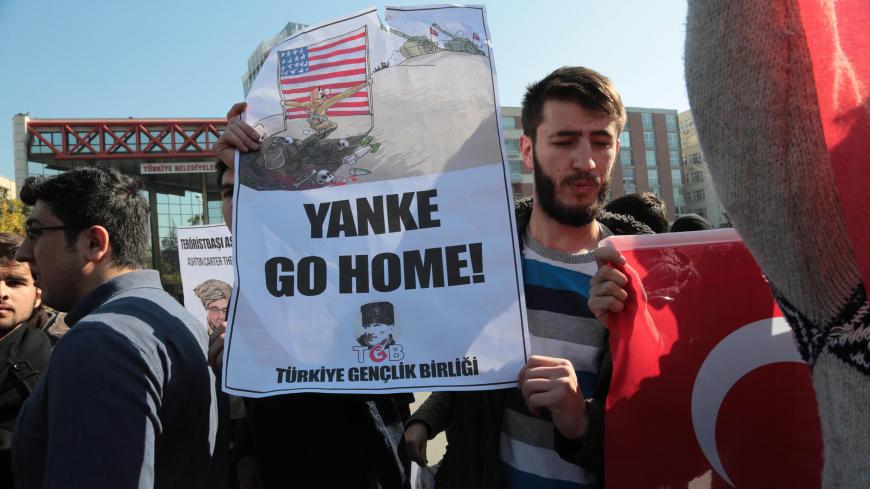 Members of the Youth Union of Turkey (Turkiye Genclik Birligi, TGB) hold signs and Turkish flags as they stage an anti-US protest outside the Parliament before a visit by the US Secretary of Defence in Ankara on October 21, 2016.
US Defence Secretary Ashton Carter arrived in Ankara on October 21 for talks with the leaders of Turkey, a crucial but sensitive ally in the fight against the Islamic State group. / AFP / ADEM ALTAN        (Photo credit should read ADEM ALTAN/AFP/Getty Images)