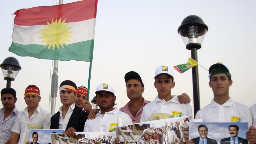 Supporters of the Patriotic Union of Kurdistan (PUK) hold and wave political posters and flags in Sulaimaniya, 260 km (160 miles) northeast of Baghdad July 9, 2009. Iraqi Kurds going to the polls this month are losing interest in age-old battles with Baghdad over land or oil, and starting to care more about corruption plaguing their largely autonomous northern region. Picture taken July 9, 2009. REUTERS/Tim Cokcs (IRAQ POLITICS ELECTIONS CONFLICT) - GM1E57E1QWK01