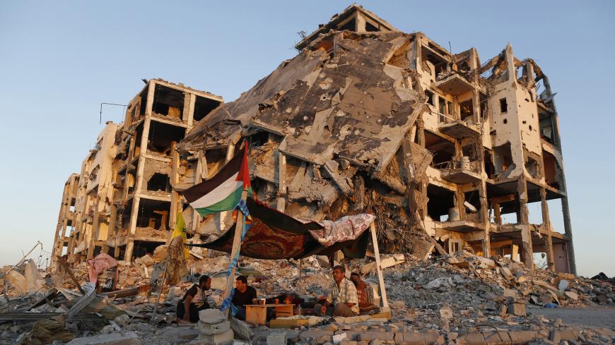 Palestinians sit in a tent outside their apartments, which witnesses said were destroyed in an Israeli offensive, during a 72-hour truce in Beit Lahiya town in the northern Gaza Strip August 11, 2014. Israeli and Palestinian negotiators resumed indirect talks mediated by Egypt on Monday on ending a month-old Gaza war, Egypt's state news agency said, after a new 72-hour truce appeared to be holding. REUTERS/Suhaib Salem (GAZA - Tags: POLITICS CIVIL UNREST) - RTR4214M