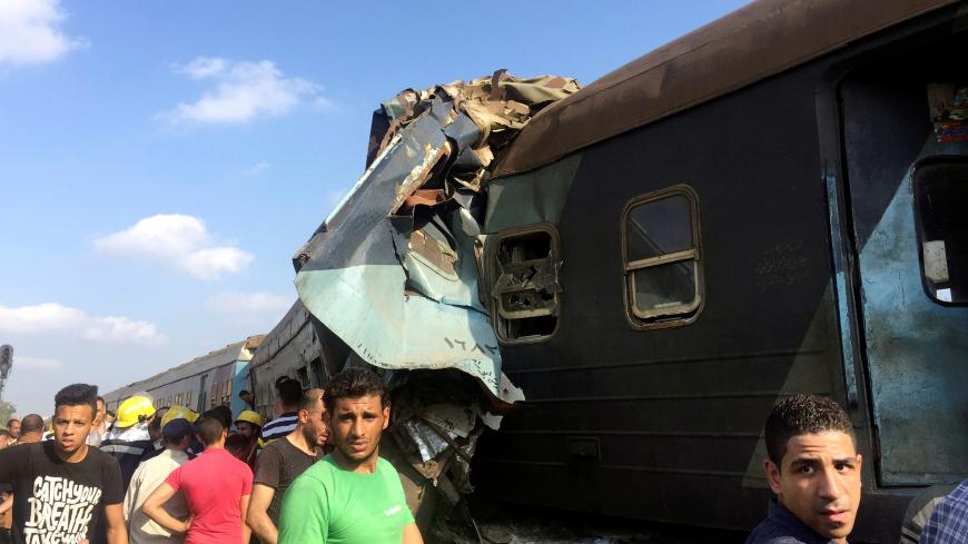 Egyptians look at the crash of two trains that collided near the Khorshid station in Egypt's coastal city of Alexandria, Egypt August 11, 2017. REUTERS/Osama Nageb - RTS1BDQ4