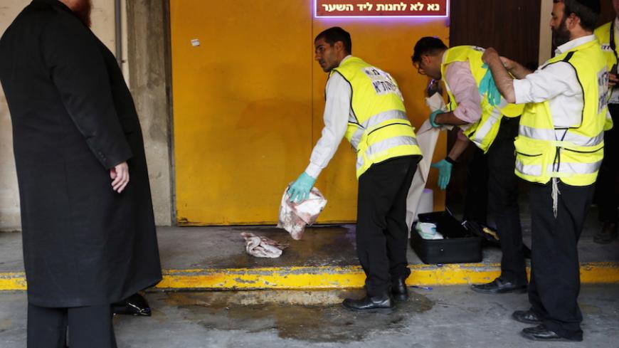 Zaka emergency personnel clean a bloodstain from the ground at the scene of a Palestinian stabbing attack in Tel Aviv, Israel November 19, 2015. REUTERS/Nir Elias - RTS7YAW
