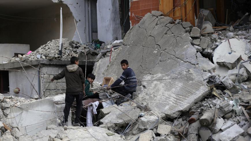 Boys stand amidst rubble of damaged buildings in the northern Syrian city of al-Bab, Syria March 13, 2017. REUTERS/Khalil Ashawi - RTX30UWO