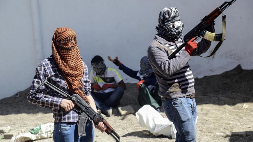 Armed Kurdish militants of the Kurdistan Workers' Party (PKK) stand behind a barricade during clashes with Turkish forces on September 28, 2015, at Bismil, in Diyarbakir. Ankara launched a major "anti-terrorist" campaign against the PKK in late July, aimed at flushing it out of its strongholds in southeastern Turkey and northern Iraq. AFP PHOTO / ILYAS AKENGIN (Photo credit should read ILYAS AKENGIN/AFP/Getty Images)