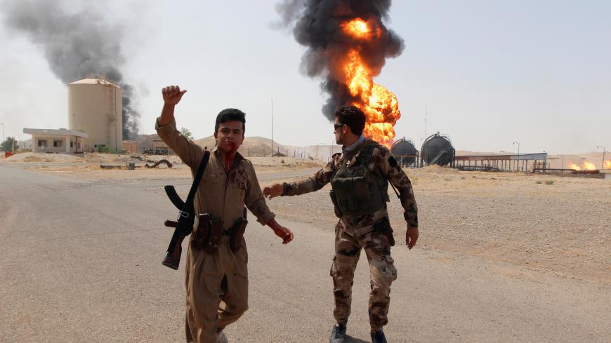 ATTENTION EDITORS - VISUAL COVERAGE OF SCENES OF INJURY An injured member of Kurdish Peshmerga forces reacts as smoke rises after an attack at Bai Hassan oil station, northwest of Kirkuk, Iraq, July 31, 2016. REUTERS/Ako Rasheed - S1BETSSSNUAB