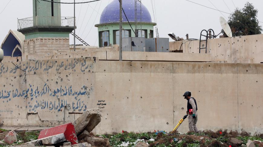 A member of an Iraqi unit searches for bombs and mines near the site of an explosion in the city of Mosul, Iraq March 19, 2017. REUTERS/Youssef Boudlal - RC11A0823EB0