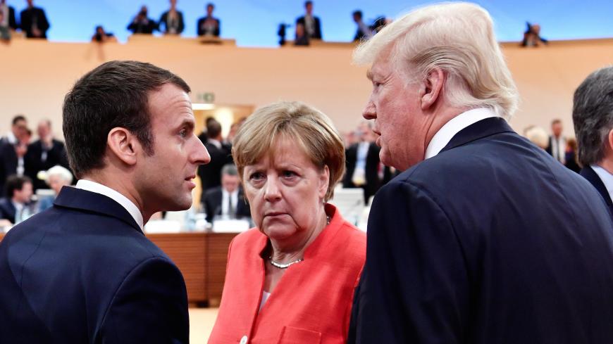 French President Emmanuel Macron, German Chancellor Angela Merkel and U.S. President Donald Trump confer s Argentinia's President Mauricio Macri walks past them at the start of the first working session of the G20 meeting in Hamburg, Germany, July 7, 2017. REUTERS/John MacDougall/Pool - RC18A478F480
