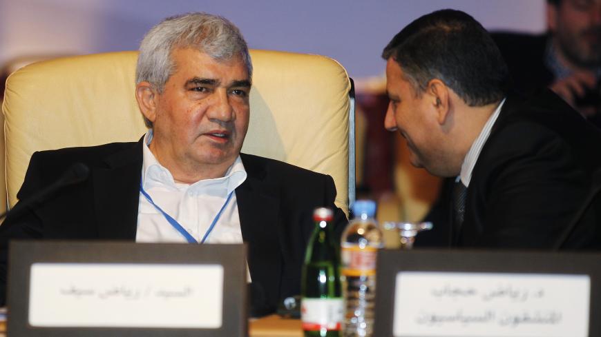 Leading Syrian dissident Riad Seif (L) speaks with former Syrian Prime Minister Riyad Hijab, who defected from the Assad regime, during the General Assembly of the Syrian National Council in Doha November 11, 2012. Syria's fractious opposition finally put aside fierce arguments to rally behind a new leader within a new coalition that its Western and Arab backers hope can topple Bashar al-Assad and take over the country. REUTERS/Mohammed Dabbous (QATAR - Tags: POLITICS CIVIL UNREST) - GM1E8BC0UXG01