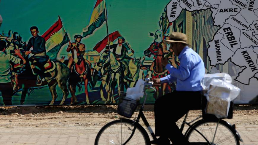 A man rides a bike near a mural supporting the referendum for independence of Kurdistan in Erbil, Iraq September 24, 2017. REUTERS/Alaa Al-Marjani TPX IMAGES OF THE DAY - RC12B8261980