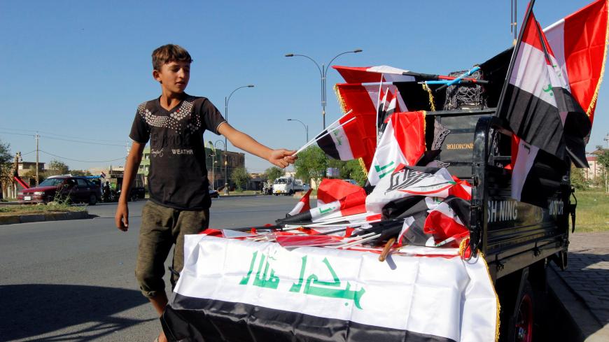 A boy sells Iraqi flags on a street in Kirkuk, Iraq October 19, 2017. REUTERS/Ako Rasheed - RC13D638D300