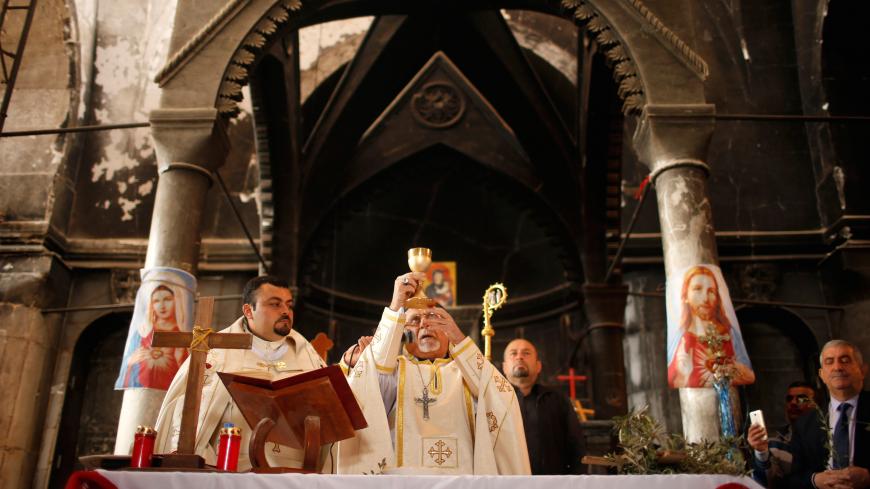 Iraqis attend the first Palm Sunday procession in the burnt out main church of the Christian city of Qaraqosh since Iraqi forces retook it from Islamic States militants, Iraq April 9, 2017. REUTERS/Suhaib Salem - RC1AB7BBA420