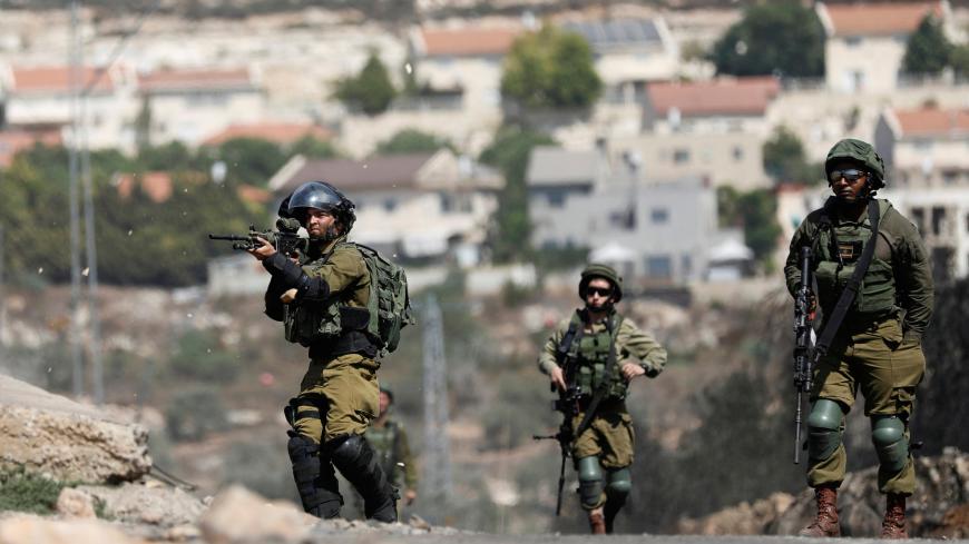An Israeli soldier aims his weapon during clashes with Palestinian protesters near the Jewish settlement of Qadomem, in the West Bank village of Kofr Qadom near Nablus September 8, 2017. REUTERS/Mohamad Torokman - RC17624D16C0