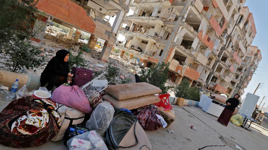 Iranians sit outside damaged homes after salvaging furniture and household appliances in the town of Sarpol-e Zahab in the western Kermanshah province near the border with Iraq, on November 15, 2017, following a 7.3-magnitude earthquake that left hundreds killed and thousands homeless days before. / AFP PHOTO / ATTA KENARE        (Photo credit should read ATTA KENARE/AFP/Getty Images)