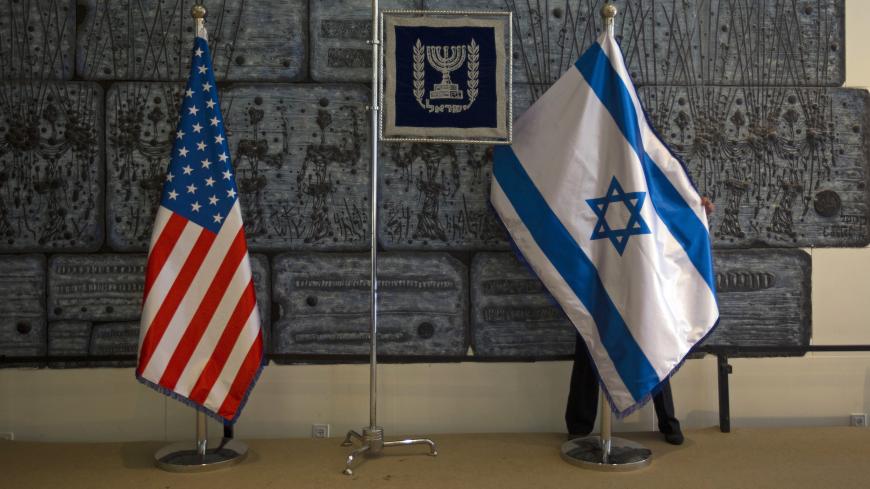 An employee arranges an Israeli national flag next to a U.S. one at the residence of Israel's President Shimon Peres in Jerusalem, ahead of U.S. President Barack Obama's visit, March 18, 2013. Obama is due to make his first official visit to Israel and the Palestinian Territories this week, looking to improve ties with both camps after a sometimes rocky first term in office. REUTERS/Ronen Zvulun (JERUSALEM - Tags: POLITICS TPX IMAGES OF THE DAY) - GM1E93I1IMJ01