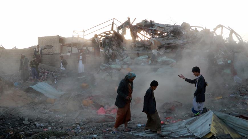 People walk at the site of an air strike in the northwestern city of Saada, Yemen November 1, 2017. REUTERS/Naif Rahma - RC132DF59570