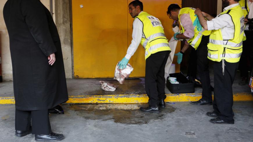 Zaka emergency personnel clean a bloodstain from the ground at the scene of a Palestinian stabbing attack in Tel Aviv, Israel November 19, 2015. REUTERS/Nir Elias - GF20000066046
