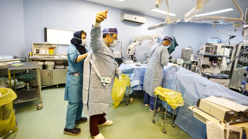Iranian surgeon Ali Manafi puts on his sterile gown before performing a nose surgery on a female patient in the operating room at a hospital in Tehran August 19,  2015. Iran has the most numbers of rhinoplasty procedures, or nose jobs, done in the world, according to local media.REUTERS/Raheb Homavandi/TIMAATTENTION EDITORS - THIS PICTURE WAS PROVIDED BY A THIRD PARTY. REUTERS IS UNABLE TO INDEPENDENTLY VERIFY THE AUTHENTICITY, CONTENT, LOCATION OR DATE OF THIS IMAGE. FOR EDITORIAL USE ONLY. NOT FOR SALE FO