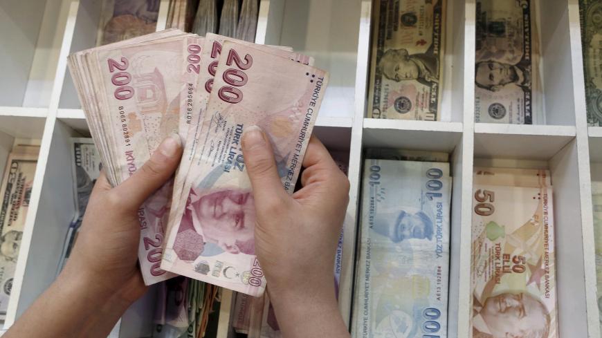 A money changer counts Turkish lira bills at an currency exchange office in central Istanbul, Turkey, August 21, 2015. Turkish consumer confidence fell to its lowest in more than six years in August, official data showed on Friday, bruised by political uncertainty, mounting militant violence in the southeast and the lira currency's tumble to a record low. REUTERS/Murad Sezer - GF10000178275