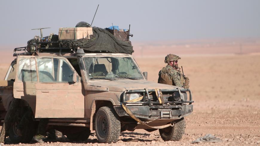 A U.S. fighter stands near a military vehicle, north of Raqqa city, Syria November 6, 2016. REUTERS/Rodi Said - S1AEULHHBDAA