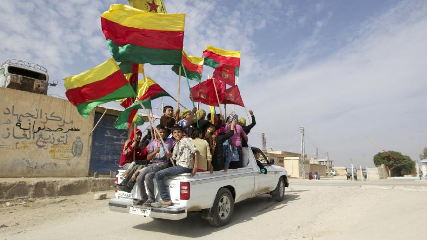 People sit in the back of a truck as they celebrate what they said was the liberation of villages from Islamist rebels near the city of Ras al-Ain in the province of Hasakah, after capturing it from Islamist rebels November 6, 2013. Redur Xelil, spokesman for the armed wing of the Syrian Kurdish Democratic Union Party (PYD), said Kurdish militias had seized the city of Ras al-Ain and all its surrounding villages. Syrian Kurdish fighters have captured more territory from Islamist rebels in northeastern Syria