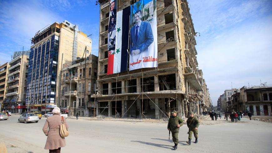 Russian soldiers and civilians walk along a street in Aleppo, Syria January 30, 2017. Picture taken January 30, 2017. REUTERS/Ali Hashisho - RC150FD10090
