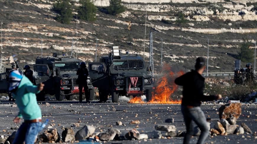 Palestinian protesters hurl stones towards Israeli troops during clashes as Palestinians call for a "day of rage" in response to U.S. President Donald Trump's recognition of Jerusalem as Israel's capital, near the Jewish settlement of Beit El, near the West Bank city of Ramallah December 8, 2017. REUTERS/Mohamad Torokman - RC1AB20A9440