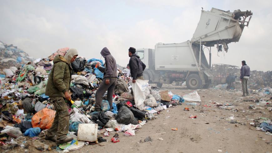 Palestinians search for recyclable waste and other items amid a pile of rubbish at a garbage dump in Rafah, in the southern Gaza Strip on April 16, 2015. AFP PHOTO / SAID KHATIB        (Photo credit should read SAID KHATIB/AFP/Getty Images)