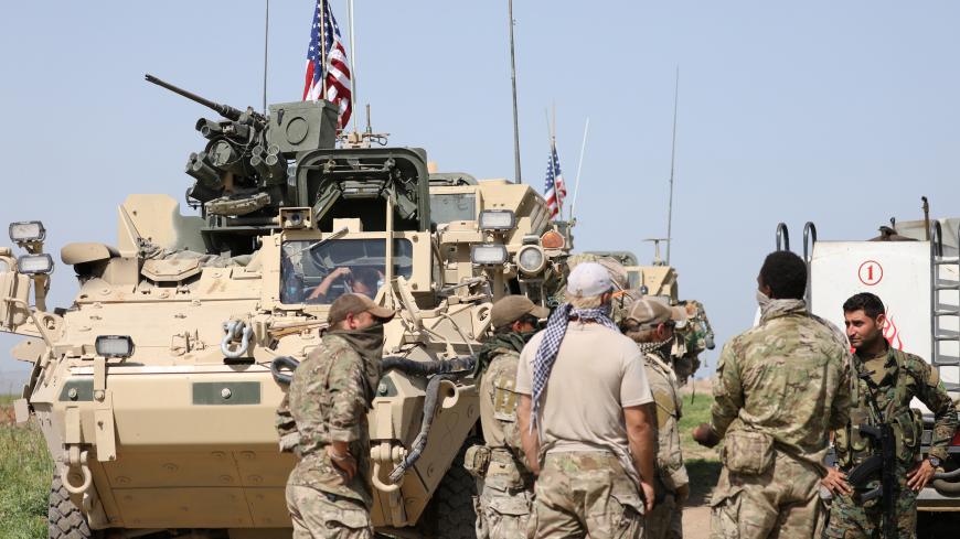 Kurdish fighters from the People's Protection Units (YPG) chat with members of U.S. forces in the town of Darbasiya next to the Turkish border, Syria April 29, 2017. Picture taken April 29, 2017. REUTERS/Rodi Said - RC16BE0EE700