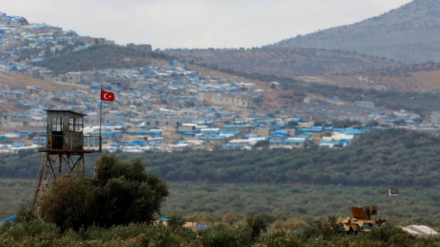 A Turkish military armoured vehicle guards on the border line located opposite the Syrian town of Atimah, Idlib province, in this picture taken from Reyhanli, Hatay province, Turkey October 10, 2017. REUTERS/Osman Orsal - RC117E0C0980