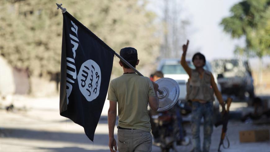 A rebel fighter takes away a flag that belonged to Islamic State militants in Akhtarin village, after rebel fighters advanced in the area, in northern Aleppo Governorate, Syria, October 7, 2016. REUTERS/Khalil Ashawi - S1AEUFQKOSAA