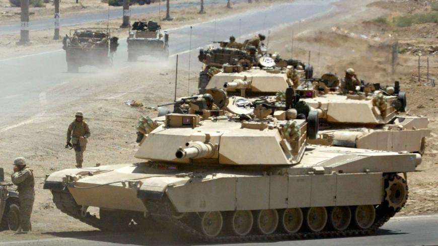 U.S. Marine M1 Abrams tanks from the 2nd Battalion of the 1st Marine Division take up defensive positions during a firefight near the main traffic checkpoint in Falluja June 24, 2004. A U.S. Marine Cobra helicopter gunship was shot down during the battle but the two pilots escaped uninjured. At least 15 insurgents were killed and three Marines injured in the fighting, a military spokesman said. REUTERS/Bob Strong  RCS/acm - RP5DRHZSARAA
