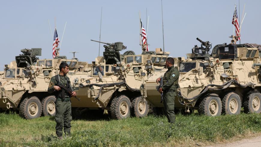 Kurdish fighters from the People's Protection Units (YPG) stand near U.S military vehicles in the town of Darbasiya next to the Turkish border, Syria April 29, 2017. Picture taken April 29, 2017. REUTERS/Rodi Said - RC16C054E9B0