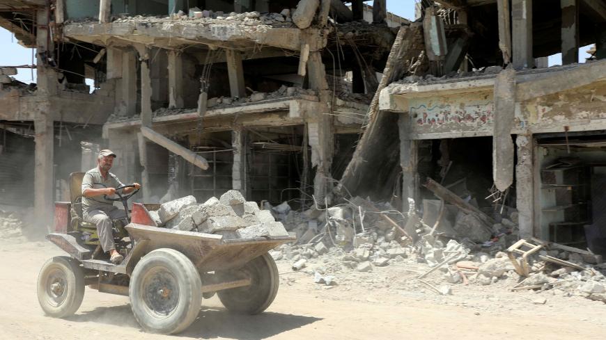 A construction worker transports bricks for the reconstruction of destroyed building in the Old City of Mosul, Iraq August 5, 2017. REUTERS/Marius Bosch - RC14F63418D0
