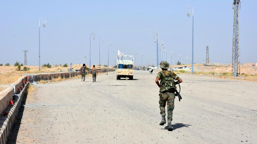 Syrian Army soldiers walk along a street in Deir al Zor, Syria in this handout picture provided by SANA on September 11, 2017. SANA/Handout via REUTERS ATTENTION EDITORS - THIS PICTURE WAS PROVIDED BY A THIRD PARTY. REUTERS IS UNABLE TO INDEPENDENTLY VERIFY THE AUTHENTICITY, CONTENT, LOCATION OR DATE OF THIS IMAGE. - RC17E35CAF70