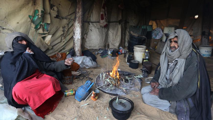 Palestinian Bedouins sit in a tent around woodfire to warm up in a Bedouin area south of Gaza City on January 7, 2015 as a major storm dumped heavy rain, high winds and snowfall on parts of the Middle East. AFP PHOTO/ MAHMUD HAMS (Photo credit should read MAHMUD HAMS/AFP/Getty Images)