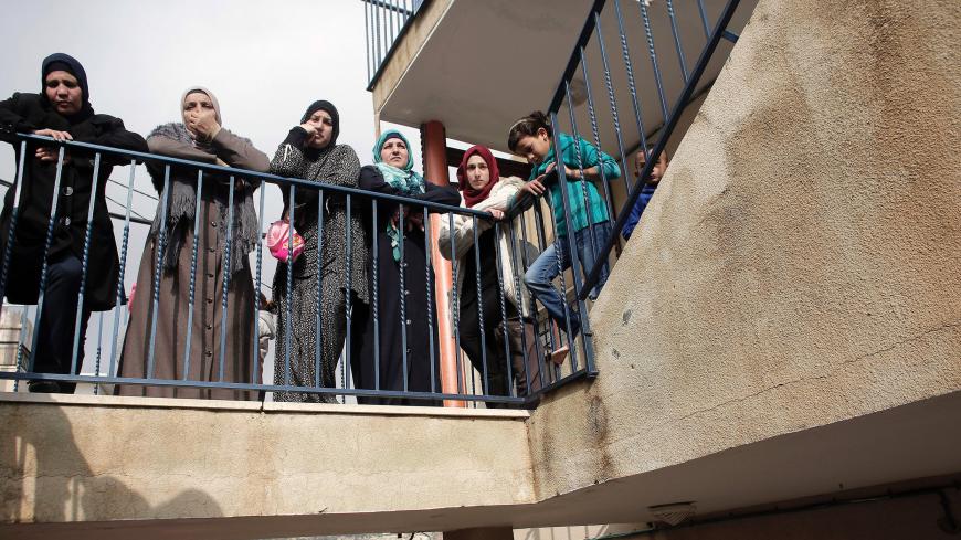 Palestinian women standing on a balcony look at the damaged interior of the home of Bahaa Allyan, a Palestinian who killed three Israelis in a shooting and stabbing attack with an accomplice on a bus in October, after Israeli forces used jackhammers to destroy the walls of the middle floor of a three-story building in the east Jerusalem Palestinian neighbourhood of Jabal Mukaber on January 4, 2016. Allyan, who was shot dead, had on October 13 along with a fellow Palestinian shot and stabbed passengers on a