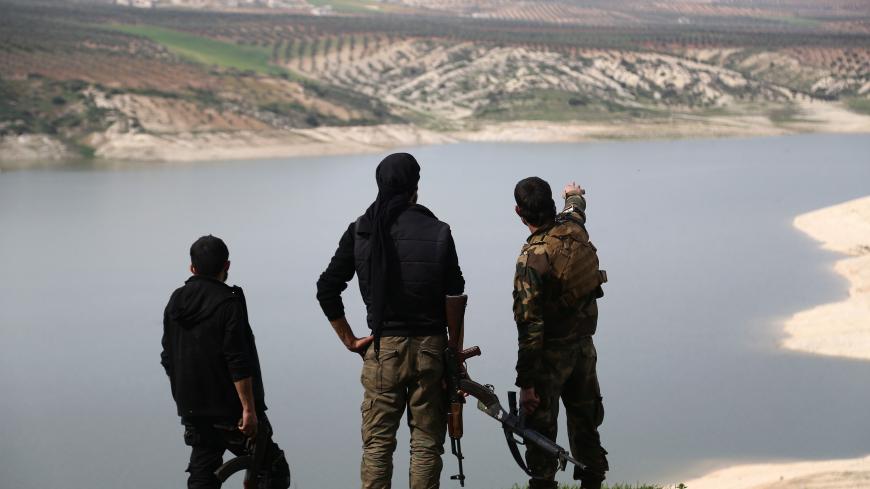 Opposition fighters look out over Lake Maydanki, north of the Syrian city of Afrin, after they took control of the nearby village of Ali Bazan on March 4, 2018. / AFP PHOTO / Nazeer al-Khatib (Photo credit should read NAZEER AL-KHATIB/AFP/Getty Images)